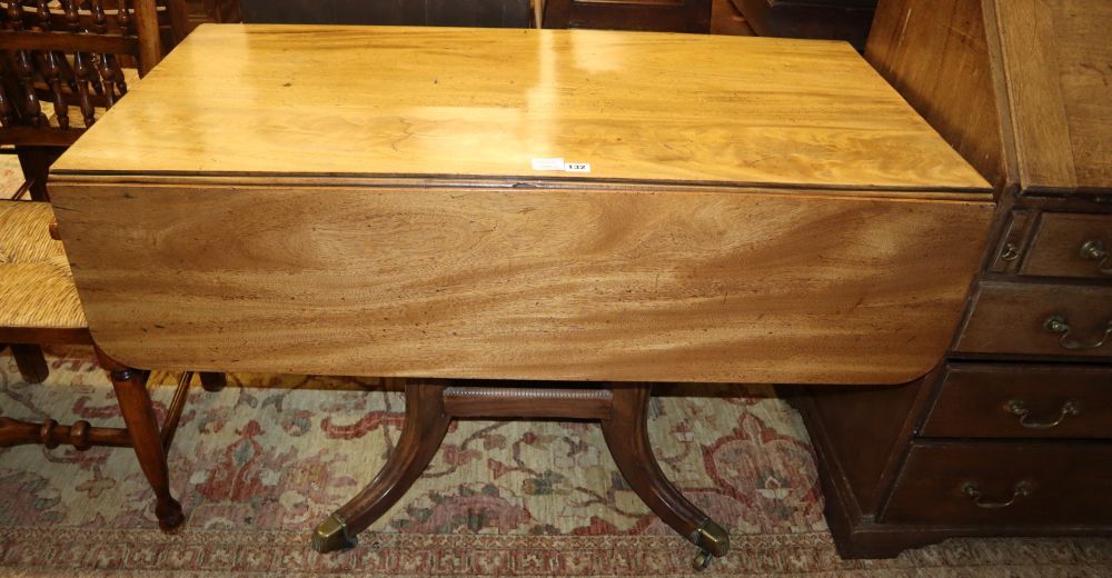 A Regency faded mahogany drop leaf breakfast table, on downswept legs with brass caps and castors, 114cm extended, W.120cm, H.74cm